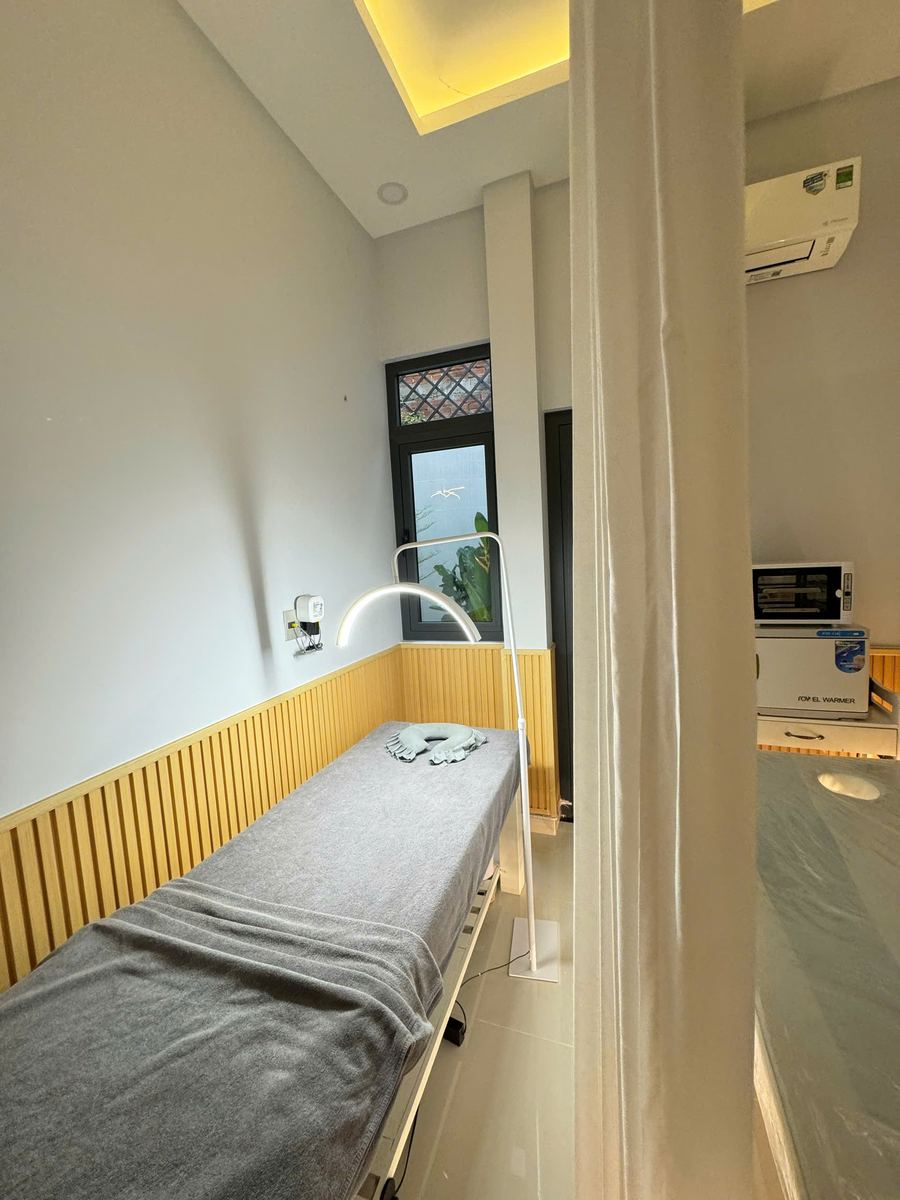 Phòng chăm sóc với giường massage và đèn soi da